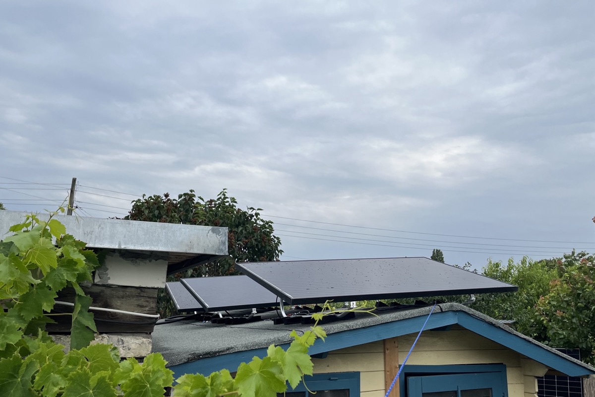 The panels on the shed roof from the side, wired down into the corner below.
